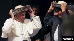 El papa Francisco y el presidente Evo Morales se colocan sombreros típicos de sao, el típico de los cruceños, con la palabra "Tahuichi" que es el nombre indio de un pájaro.