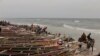 Une charrette à cheval roule dans l'eau le long de bateaux de pêche bordant une plage au bord de l'océan, à Saint-Louis, Sénégal, le dimanche 19 mai 2013. (AP Photo / Rebecca Blackwell)