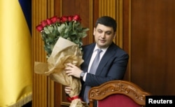 FILE - Newly-appointed Ukrainian Prime Minister Volodymyr Groysman holds a bouquet of flowers at the parliament in Kyiv, Ukraine, April 14, 2016.