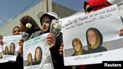 Phụ nữ cầm hình con tin người Pháp Isabelle Prime (phải) và thông dịch viên người Yemen của cô trong cuộc biểu tình kêu gọi trả tự do cho họ tại San'aa, Yemen.