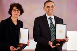 FILE - German scientists, CEOs and founders of BioNTech, Ozlem Tureci and Ugur Sahin pose with the Bundesverdienstkreuz (Federal Cross of Merit) awarded to them by German President Frank-Walter Steinmeier.
