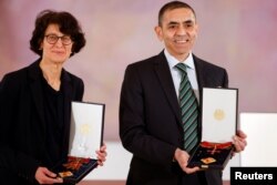 FILE - German scientists, CEOs and founders of BioNTech, Ozlem Tureci and Ugur Sahin pose with the Bundesverdienstkreuz (Federal Cross of Merit) awarded to them by German President Frank-Walter Steinmeier.