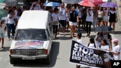 Relatives and supporters follow the hearse of Leover Miranda during his funeral, Aug. 20, 2017 in Manila, Philippines. 