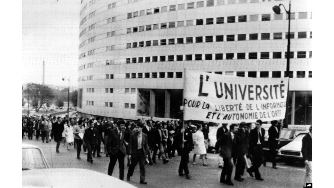 FILE - Paris students march on June 9, 1968, around the French Maison de la Radio in support of the striking TV and radio employees. The banner reads The University for the Liberty of News and the Autonomy of the ORTF (the Government controlled TV and radio system). Daily marches have been organized around the Radio House during the strike.