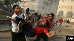 Student supporters of ousted president Mohamed Morsi carry a comrade injured during clashes with Egyptian security forces outside Al-Azhar university in Cairo on October 28, 2013.