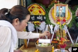 Sam Chanthy, wife of Chut Wutty, lights incense during Wutty's funeral at his house in Kandal province, Cambodia, April 28, 2012.