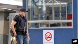 북한 김정은 국무위원장의 이복형 김정남의 시신이 안치된 말레이시아 쿠알라룸푸르 병원의 법의학실에서 2일 기관총을 찬 경찰이 걸어나오고 있다.