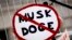Seorang demonstran memamerkan poster yang bertuliskan tanda larangan bertuliskan "Musk Doge" dalam unjuk rasa memprotes kebijakan Presiden Donald Trump pada Hari Presiden, Senin, 17 Februari 2025. (Foto: Etienne Laurent/AP Photo)