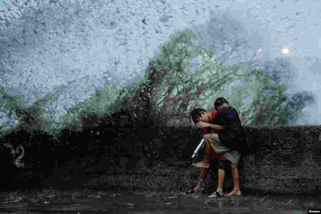 Children play near strong waves from the Pasig River amid Super Typhoon Man-yi, in Manila, Philippines.