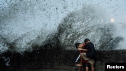 Children play near strong waves from the Pasig River amid Super Typhoon Man-yi, in Manila, Philippines.