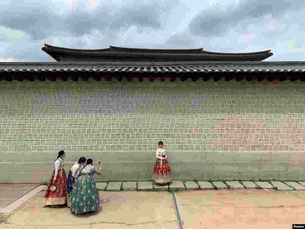 Tourists dressed in traditional Korean costumes take pictures during the visit to Gyeongbokgung Palace in Seoul, South Korea.