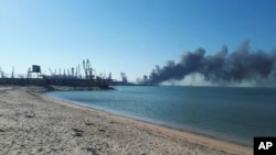 (FILE) Smoke rises after shelling near a seaport in Berdyansk, Ukraine, Thursday, March 24, 2022.