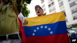 Una mujer sostiene una bandera durante una protesta contra la reelección del presidente Nicolás Maduro en Caracas, Venezuela, el sábado 28 de septiembre de 2024. (Foto AP/Ariana Cubillos)