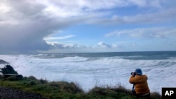 Seorang pria mengabadikan gelombang pasang ekstrem di Rodea Point, di Lincoln County, Oregon, 11 Januari 2020. (Foto: AP)