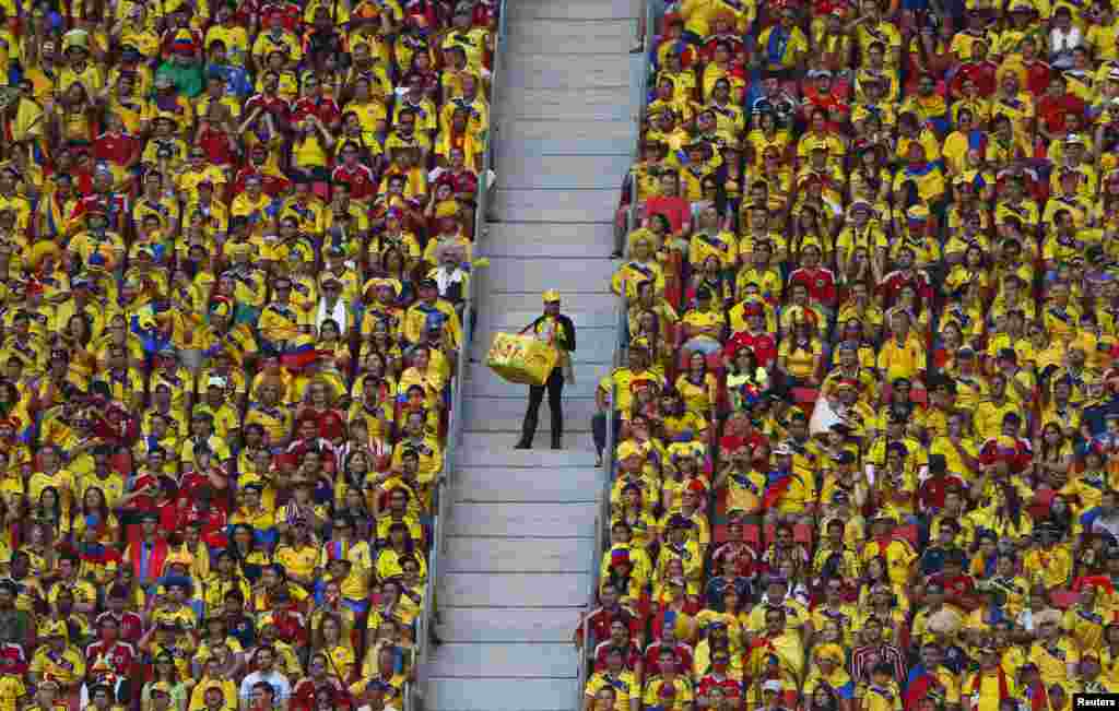 A vendor walks down the stairs as fans watch the 2014 World Cup Group C soccer match between Ivory Coast and Colombia at the Brasilia national stadium in Brazil.