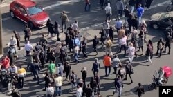 (FILE) People blocking an intersection during a protest to mark 40 days since the death in custody of 22-year-old Mahsa Amini, in Tehran, Iran, Wednesday, Oct. 26, 2022. 