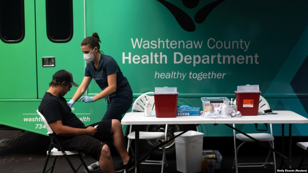 Seorang perawat bersiap menyuntikkan vaksin COVID-19 kepada seorang pria dalam sebuah acara vaksinasi massal di Ypsilanti, Michigan, Sabtu, 7 Agustus 2021. (Foto: Emily Elconin/Reuters)