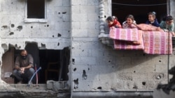 Anak-anak bermain di balkon apartemen di sebelah seorang pria yang sedang memeriksa kerusakan setelah serangan Israel di kamp Nuseirat, di Jalur Gaza bagian tengah, 10 Desember 2024. (Eyad BABA / AFP)