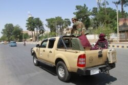 Taliban fighters sit on the back of a vehicle in the city of Herat, west of Kabul, Afghanistan, Saturday, Aug. 14, 2021, after they took this province from Afghan government. The Taliban seized two more provinces and approached the outskirts of…