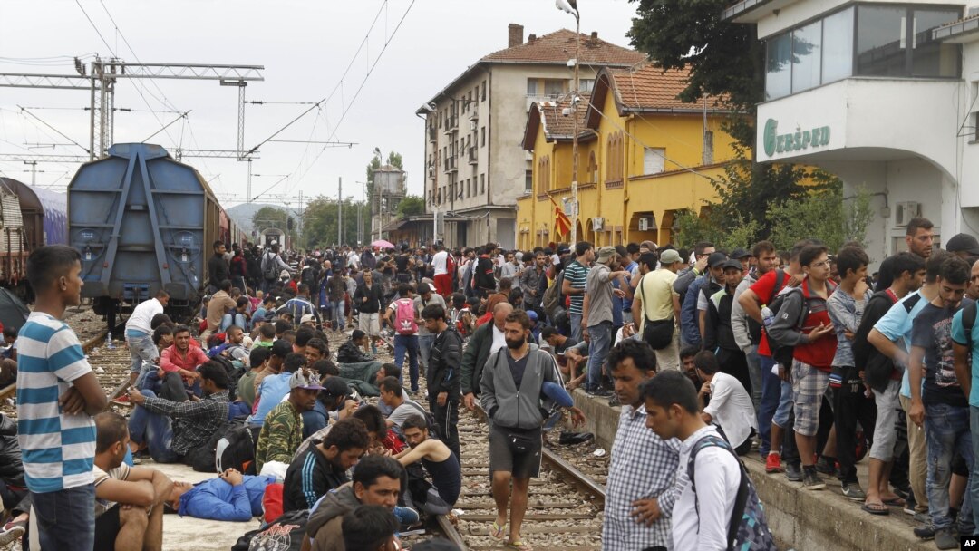 Para migran tiba di stasiun kereta Gevgelija di Makedonia setelah menerobos blokade polisi di perbatasan Yunani (22/8). (AP/Boris Grdanoski)