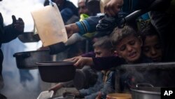 Palestinians line up for a meal in Rafah, Gaza Strip, on Feb. 16, 2024. International aid agencies say Gaza is suffering from shortages of food, medicine and other basic supplies as a result of the war between Israel and Hamas. 