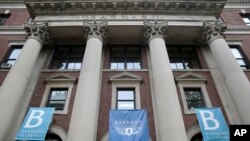 FILE - In this May 28, 2015 photo, banners hang from a building at Barnard College in New York. 