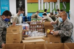Airman First Class Binh Pham, right, and other members of the Oklahoma Air National Guard fill emergency food boxes at the Regional Food Bank Thursday, April 23, 2020, in Oklahoma City.