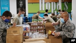 Airman First Class Binh Pham, right, and other members of the Oklahoma Air National Guard fill emergency food boxes at the Regional Food Bank in Oklahoma City, April 23, 2020. 