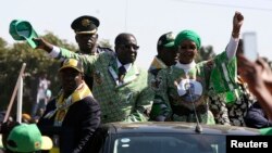 Zimbabwean President Robert Mugabe (C) and his wife Grace wave to supporters at an election rally in Chitungwiza, about 35 kilometers south of the capital Harare, July 16, 2013.