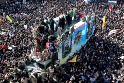 Coffins of Gen. Qassem Soleimani and others who were killed in Iraq by a U.S. drone strike, are carried on a truck surrounded by mourners during a funeral procession, in the city of Kerman, Iran, Jan. 7, 2020.
