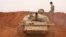 Syrian rebel-fighters from the National Liberation Front (NLF) secure a tank, part of heavy weapons and equipment withdrawn yesterday from a planned buffer zone around Idlib in one of the group's rear positions in a rebel-held area in the southwestern Syrian province on Oct. 9, 2018.