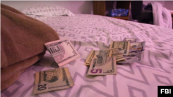 FILE - Money is seen on a bed used for prostitution during a 2017 multi-agency initiative to recover people who were trafficked in this US Federal Bureau of Investigation photo.