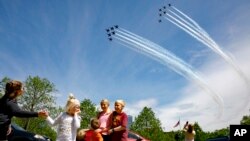 The Ferry family, who were in the middle of taking a family photograph in Arlington, Virginia, are surprised by a second flyover by the Blue Angels and Thunderbirds, in a 'salute to front-line COVID-19 responders' on May 2, 2020.
