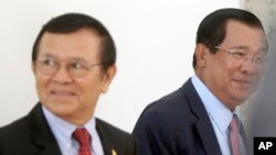 File photo - Cambodia's Prime Minister Hun Sen, right, walks with opposition Cambodia Rescue Party Deputy President Kem Sokha, left, during a break at National Assembly in Phnom Penh, Cambodia, Wednesday, Dec. 7, 2016. 