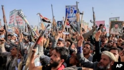 FILE - Houthi supporters raise weapons as they shout slogans during an anti-U.S and anti-Israel rally in Sanaa, Yemen, on Feb. 14, 2025. The U.S. State Department on March 4, 2025, designated the Iran-backed group as a "foreign terrorist organization."