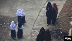 Dua kelompok siswi dari dua sekolah berbeda berpapasan di jalan di kawasan Kaliangkrik, Magelang, Jawa Tengah. (Foto: VOA/Nurhadi)