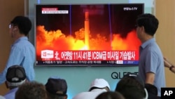 FILE - People watch a TV news program showing an image of North Korea's latest test launch of an intercontinental ballistic missile at the Seoul Railway Station in Seoul, South Korea, July 29, 2017.