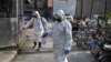 Petugas Kesehatan Darurat menyemprotkan cairan disinfektan di sebuah kawasan di Wuhan, China di tengah merebaknya wabah corona virus, 30 Januari 2020. (Foto: AFP)