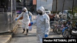 Petugas Kesehatan Darurat menyemprotkan cairan disinfektan di sebuah kawasan di Wuhan, China di tengah merebaknya wabah corona virus, 30 Januari 2020. (Foto: AFP)