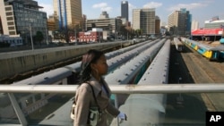 A Johannesburg resident walks on Mandela Bridge over railroad tracks in Johannesburg, South Africa, June 29, 2006. 