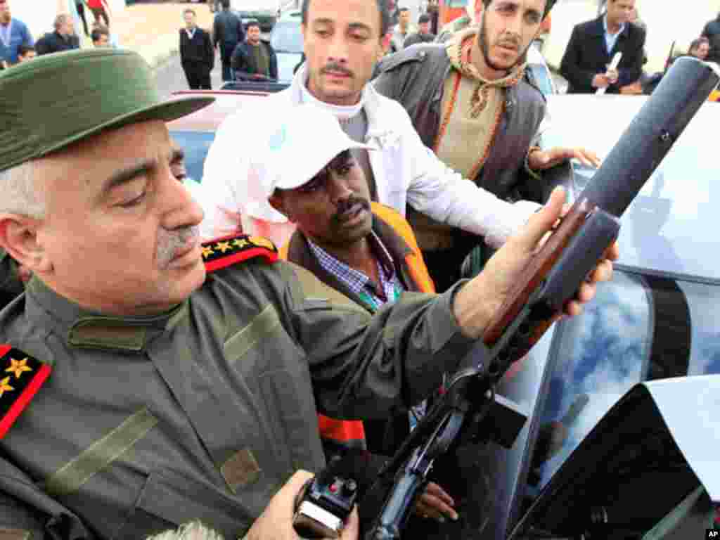 A Syrian officer shows an Arab league monitor a weapon the official says was confiscated from gun men, during the tour of Arab monitors outside Damascus in Harasta, January 26,2012. (Reuters)