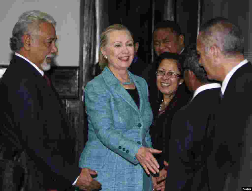 U.S. Secretary of State Hillary Clinton (C) shakes hands with staff members next to East Timor's Prime Minister Xanana Gusmao (L) at the Prime Minister's office in Dili September 6, 2012. 