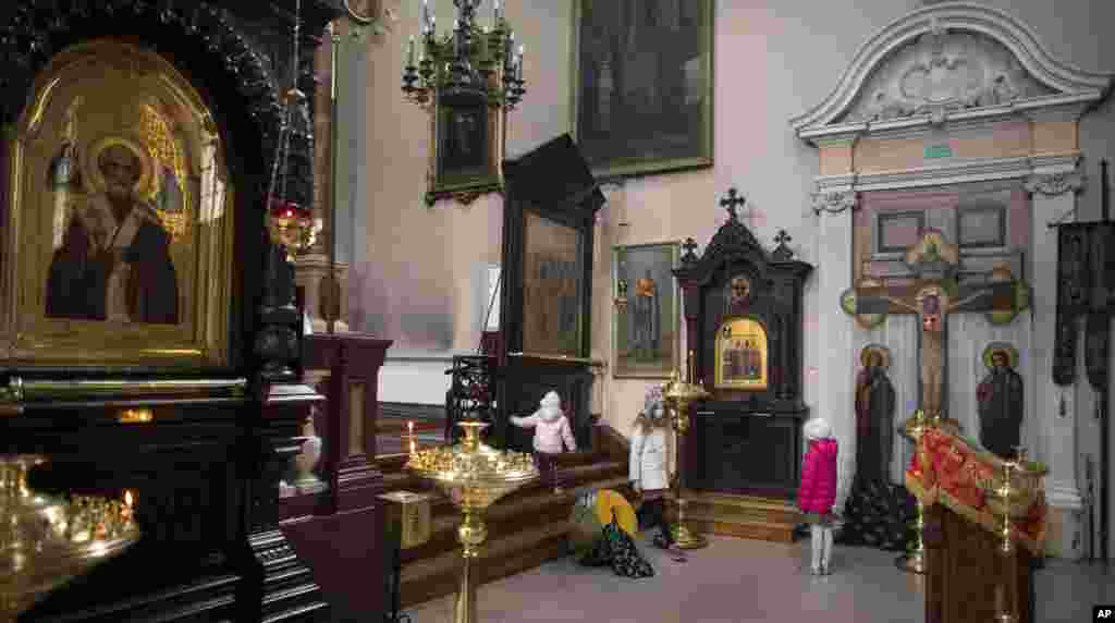 Una madre reza con sus hijos durante la Pascua ortodoxa en la Iglesia ortodoxa del Espíritu Santo en Vilnius, Lituania, este domingo.