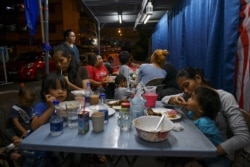 FILE - People eat near a public housing complex in Kuala Lumpur, Malaysia April 21, 2018.