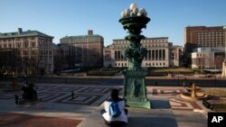 Seorang perempuan duduk di kampus Universitas Columbia, Senin, 9 Maret 2020, di New York. (Foto: AP)