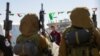 Hamas militants escort Israeli Russian hostage Sasha Trupanov before handing him over to a Red Cross team in Khan Yunis, southern Gaza Strip, on Feb. 15, 2025, as part of the sixth hostage-prisoner exchange.