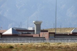 FILE - This Oct. 15, 2015 file photo shows a guard tower looming over a federal prison complex which houses a Supermax facility outside Florence, Colorado.