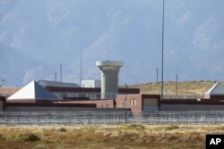 FILE - This Oct. 15, 2015 file photo shows a guard tower looming over a federal prison complex which houses a Supermax facility outside Florence, Colorado.