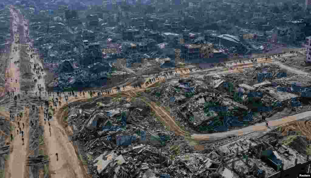 A drone view shows displaced Palestinians walking past the rubble as they attempt to return to their homes, amid a ceasefire between Israel and Hamas, in the northern Gaza Strip, Jan. 19, 2025. 