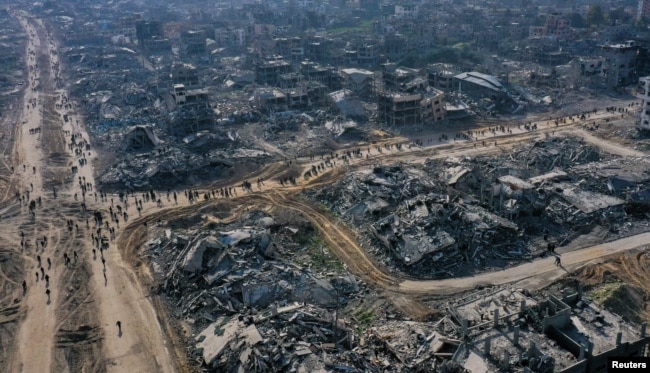 A drone view shows displaced Palestinians walking past the rubble as they attempt to return to their homes, amid a ceasefire between Israel and Hamas, in the northern Gaza Strip, Jan. 19, 2025.